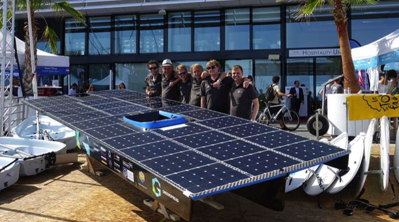 a university solar boat team poses with their boat