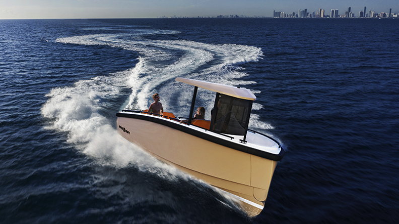 A Dutchcraft electric boat speeds along the sea with a city skyline far in the bakground