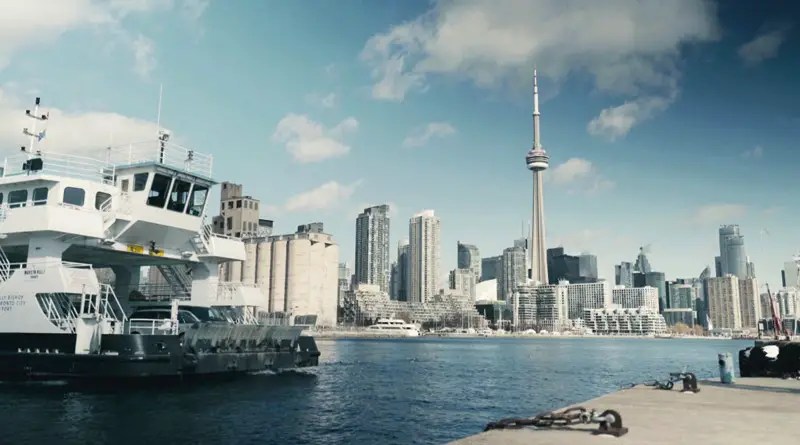 The bow of the battery-powered ferry with Toronto's CN Tower in the background