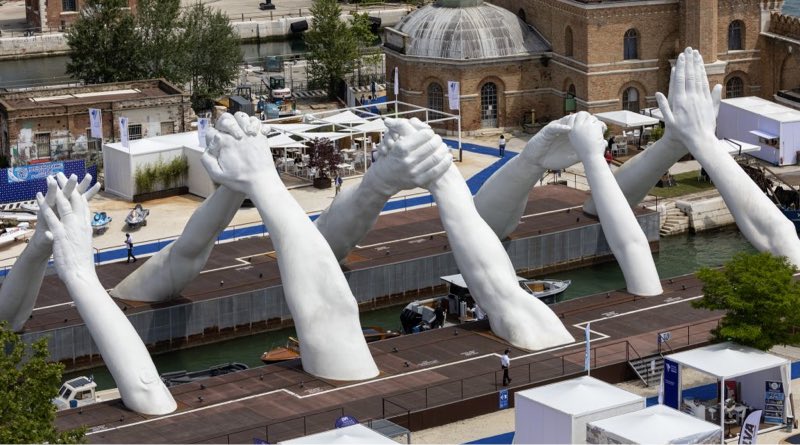 Venice Boat Show - huge sculpted arms with hands clasped as arches over Venice canal